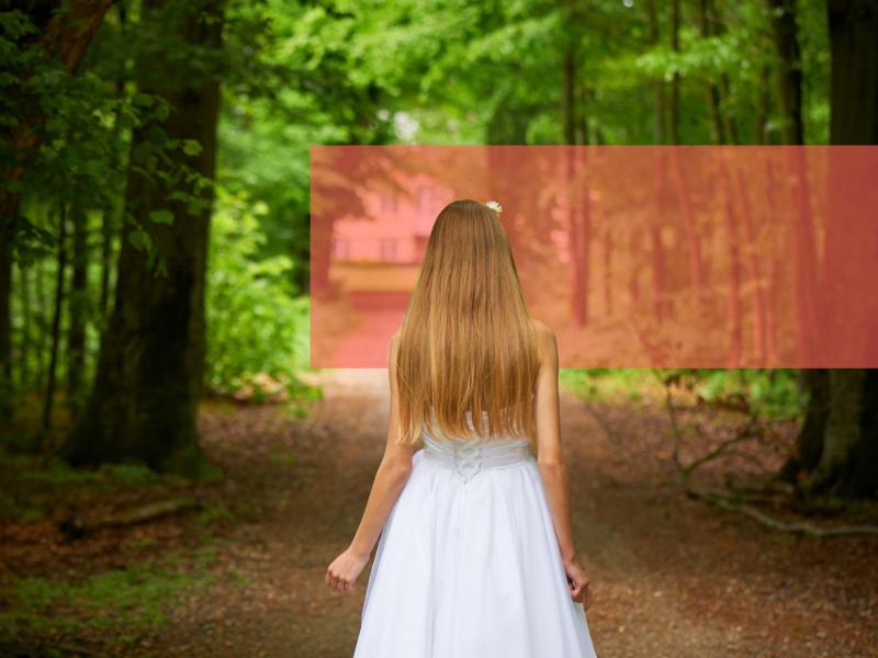 Konfirmand i hvid kjole på vej i bøgeskov