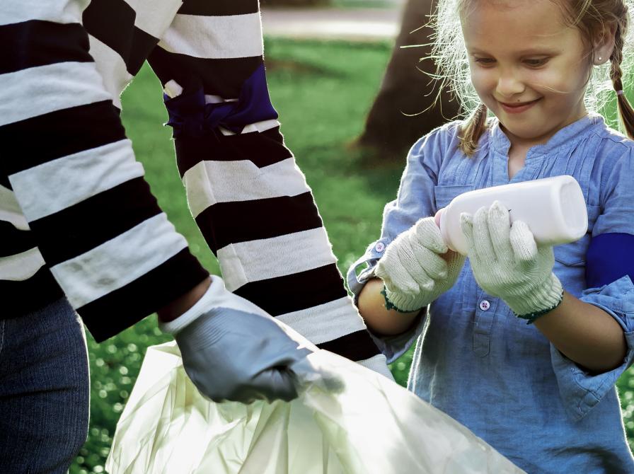 Pige og dame samler skrald i stor sæk